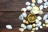 Seashells and compass lie on a wooden table