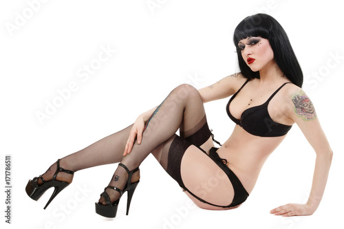 Young beautiful sexy gothic girl in garter belt, stockings and stilettos over white background