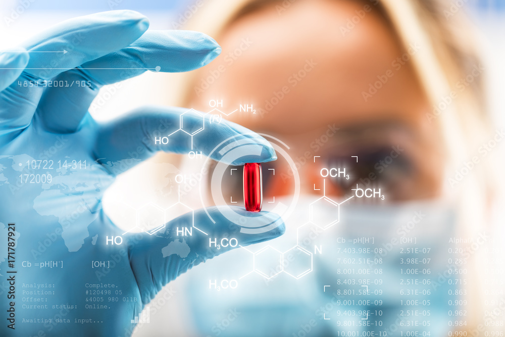 Young attractive female scientist holding a red transparent pill - obrazy, fototapety, plakaty 