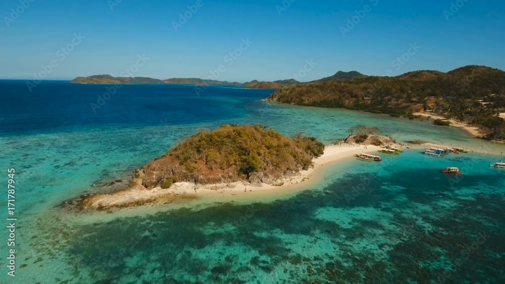 Aerial view of tropical beach on the Bulog Dos Island, Philippines. Beautiful tropical island with sand beach, palm trees. Tropical landscape: beach with palm trees. Seascape: Ocean, sky, sea. 4K