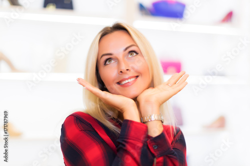 Portrait of young dreaming woman in the fashion store