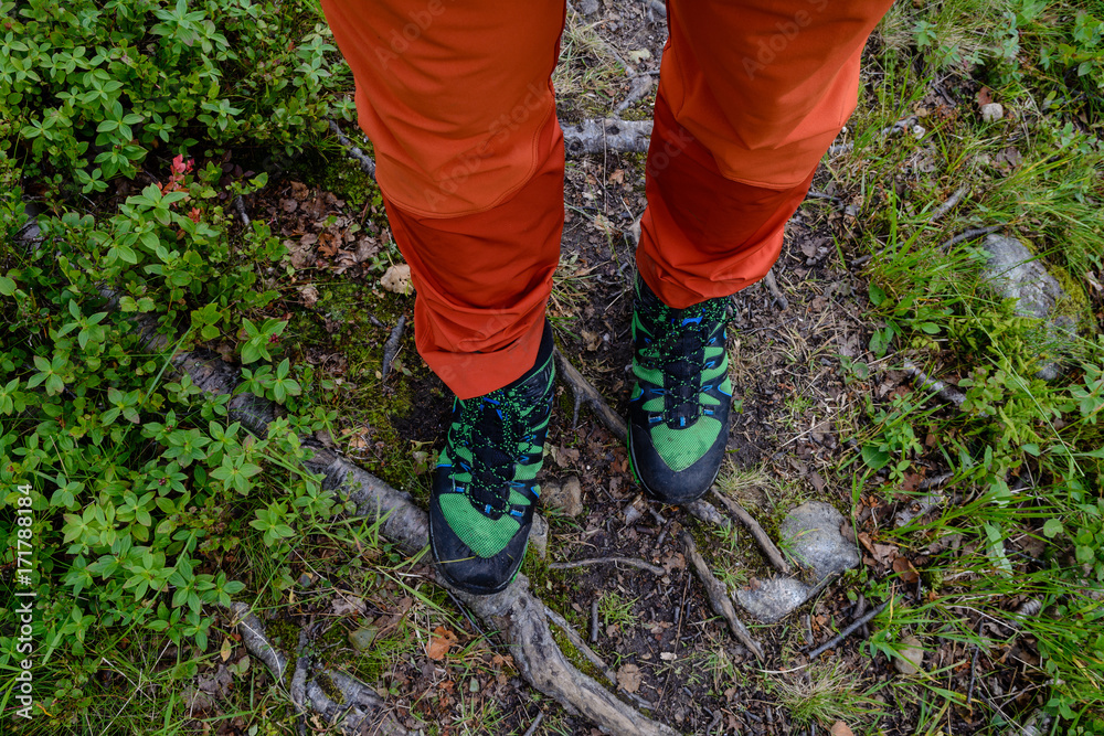Fototapeta premium Hiker with red pants and green hiking shoes on path