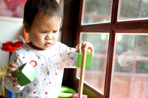 Toddler girl, baby girl paly with wooden toy, serious mode 1.7 years old