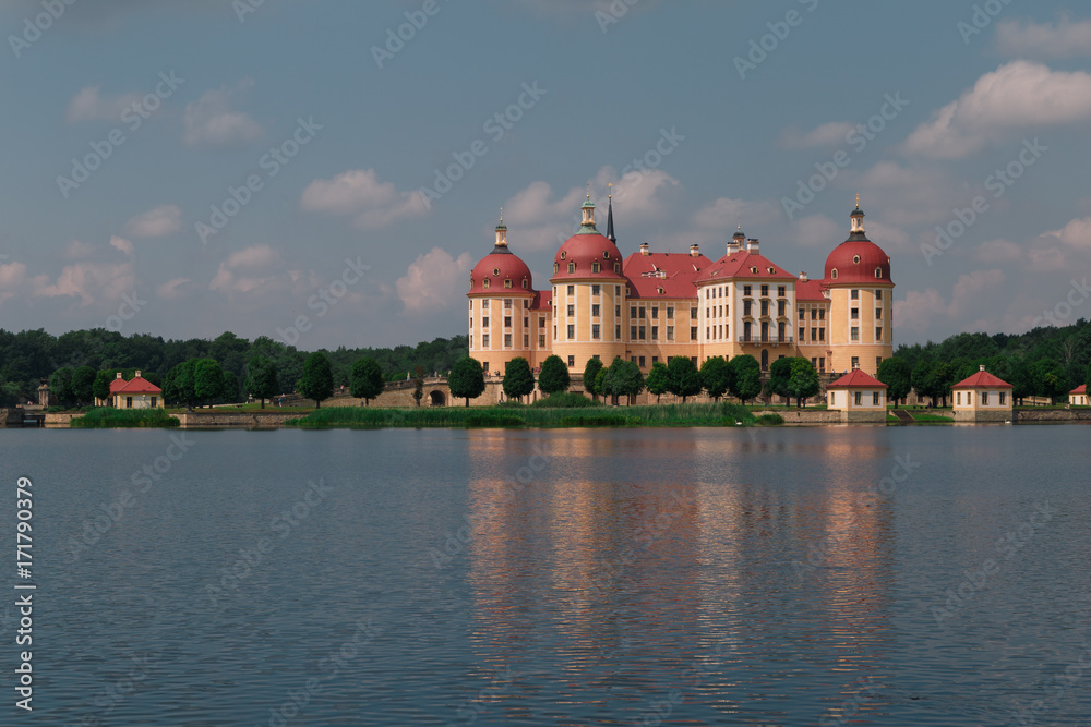 Schloss mit rotem Dach und Spiegelung im Wasser