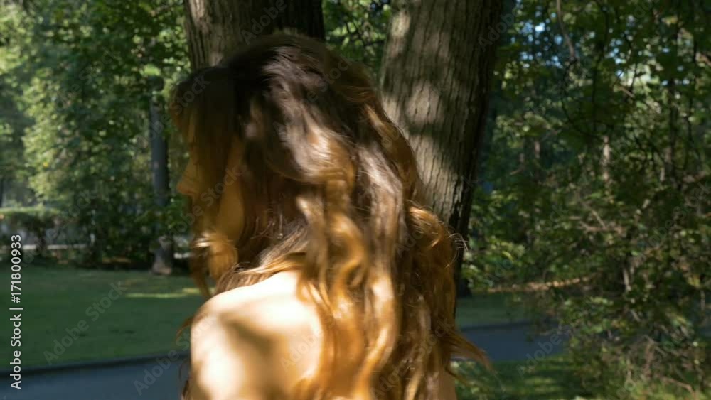 Young beautiful woman with red hair is walking in the park. Stock Video ...