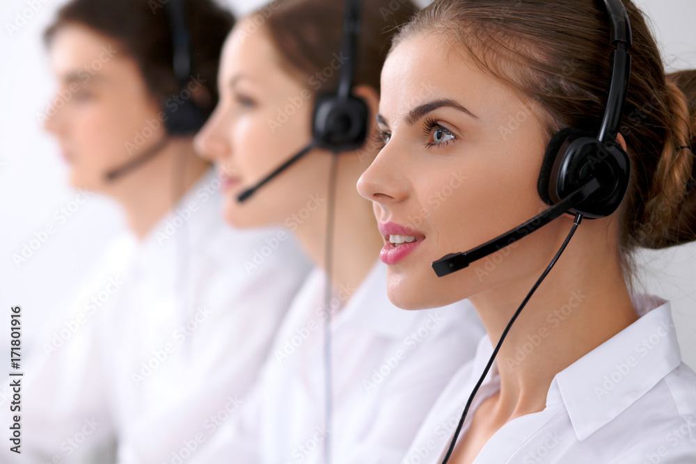 Call center. Focus on beautiful woman in headset Call center. Focus on beautiful woman in headset