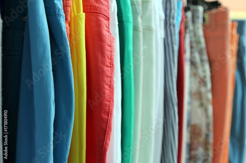 Shallow focus shot of colorful trousers and jeans on a shop rail