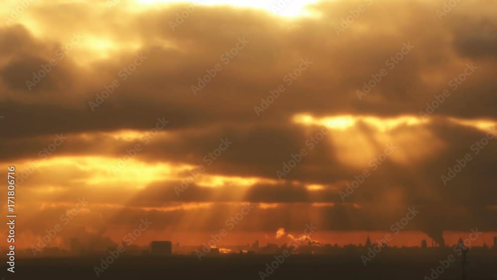 Light coming through dense clouds at sunset over the city
Light coming through dense clouds at sunset over the city