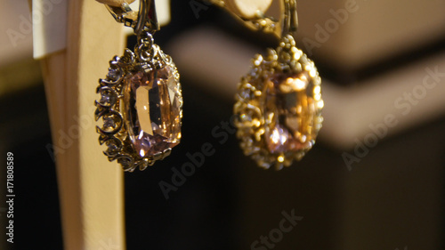 Golden earrings with gemstone. Earrings with precious stones