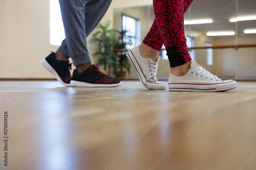Low section of man with friend rehearsing dance on floor Low section of man with friend rehearsing dance on floor
