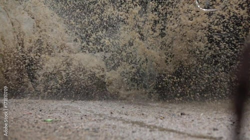 Wallpaper Mural SLOW MOTION CLOSE UP: Detail of a SUV car tyre driving over deep puddle and splashing water across the dirt road. Black SUV car tires driving on wet dirt road after rain and over muddy puddle. Torontodigital.ca