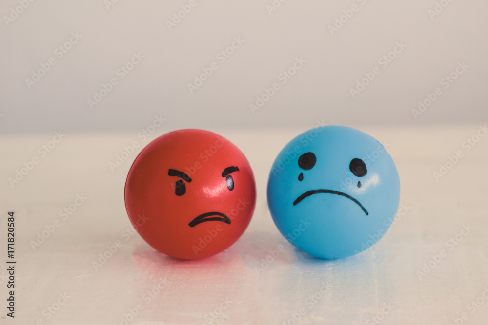 Emotions balls: Anger red ball and sad depressed blue ball - obrazy, fototapety, plakaty 