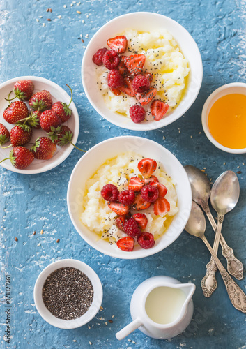 Sweet rice porridge with berries on a light background, top view. Healthy breakfast or dessert
