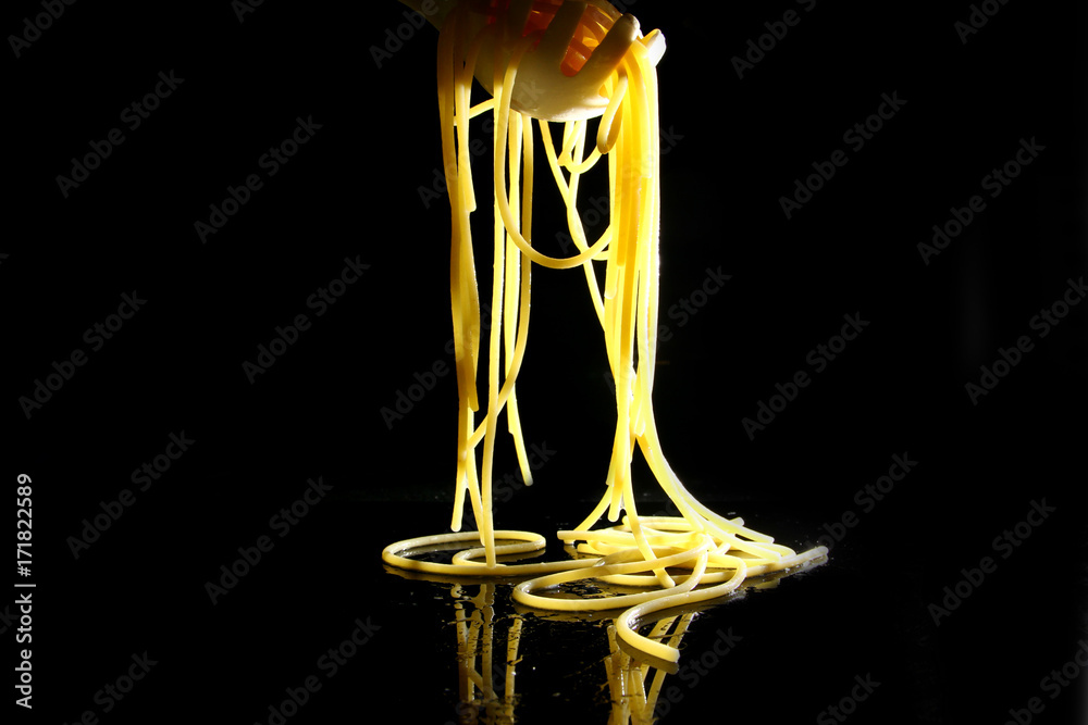 Pasta background / Spaghetti is a long, thin, cylindrical, solid pasta. It is a staple food of traditional Italian cuisine. Like other pasta, spaghetti is made of milled wheat and water.