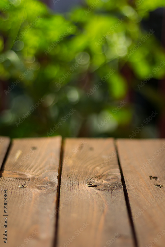 Wooden table on the terrace with green leaves in the background Wooden table on the terrace with green leaves in the background