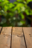 Wooden table on the terrace with green leaves in the background
