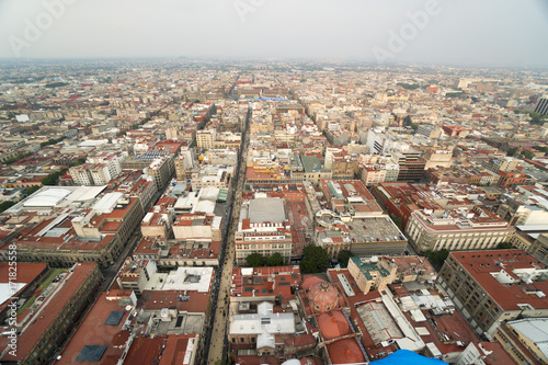 Bird's-eye panoramic view to roofs of ancient houses, buildings, central square park and streets in the city at summer sunny day