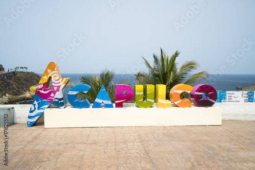 Colorful Acapulco inscription sign with bright colorful letters on a shoreline in summer sunny day photo