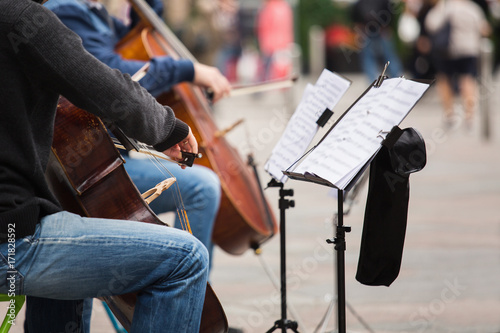 A group of musicians playing cellos on a street in a European city photo
