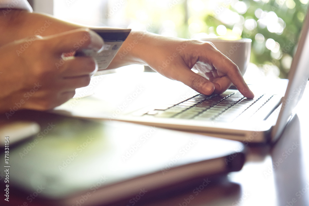 Hands holding credit card and using laptop. Online shopping, Travel booking concept. Selective focus. Hands holding credit card and using laptop. Online shopping, Travel booking concept. Selective focus.