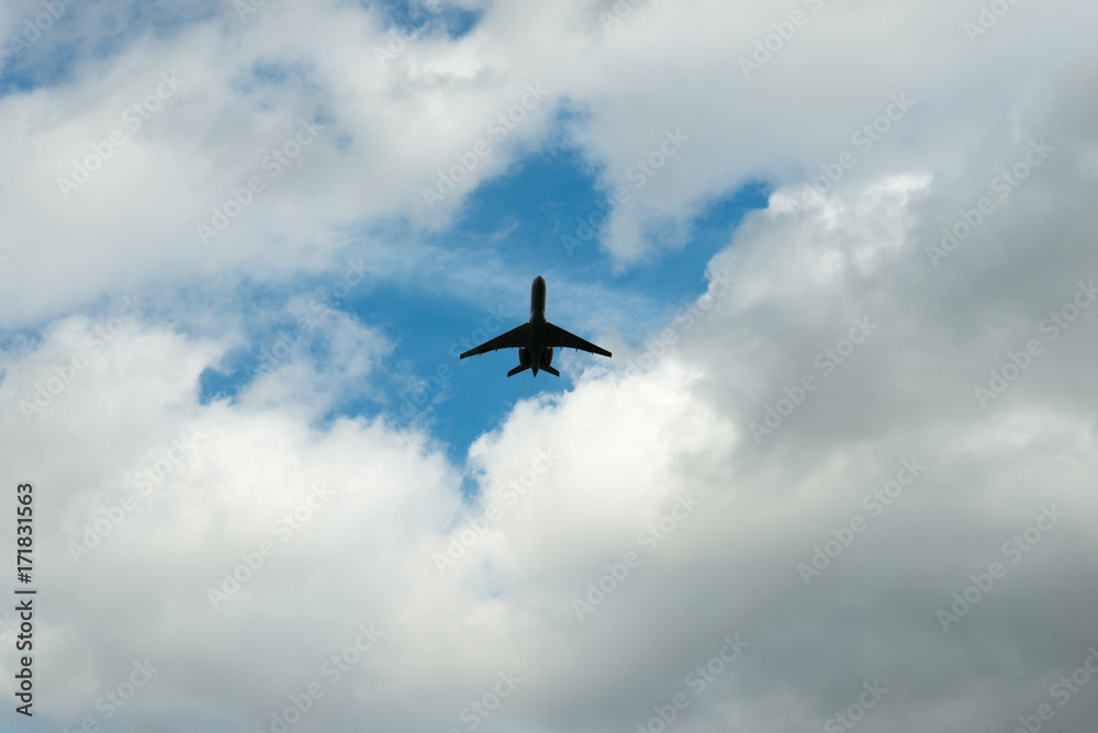 Fototapeta premium Jet Plane in a blue Sky surrounded by white clouds