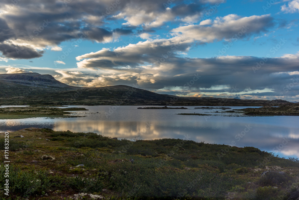 Clouds reflecting on a Norwegian lake at sunset in the Rondane National Park in Norway