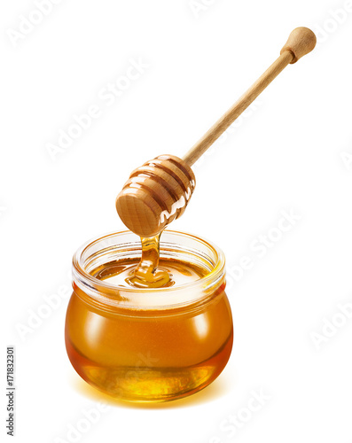 Honey dripping isolated from dipper into jar
