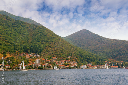Seaside village of Lepetane with boats sailing along the coastline. Bay of Kotor (Adriatic Sea), Montenegro, autumn