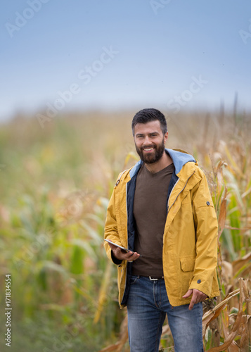 Farmer with tablet in corn field