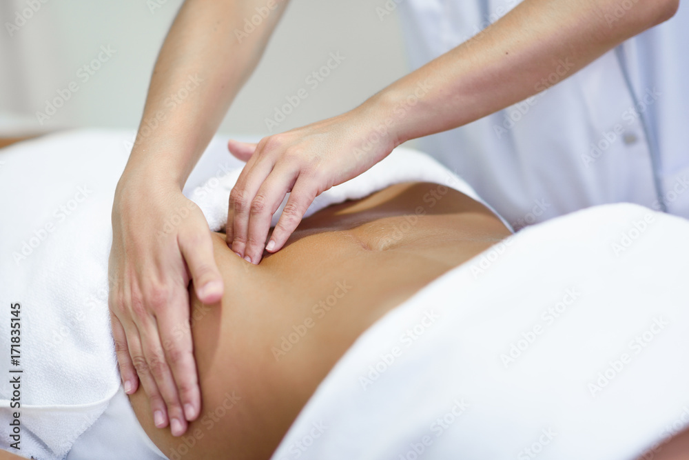 Woman receiving a belly massage at spa salon Woman receiving a belly massage at spa salon