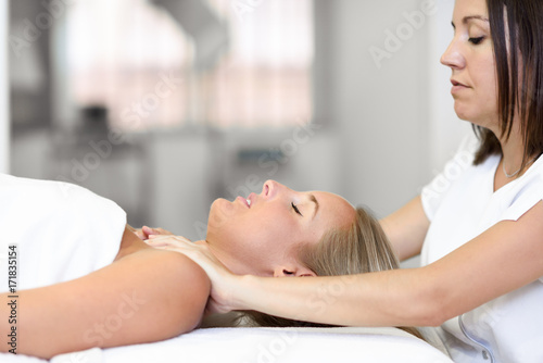 Young woman receiving a head massage in a spa center.