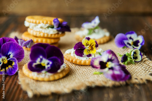 Sandwich with herb and edible flowers butter on wooden background, healthy food. photo