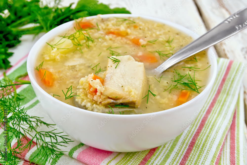 Soup fish with millet and spoon on board Soup fish with millet and spoon on board