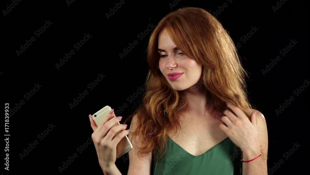 Girl makes selfie on her smartphone. Black background. Slow motion Girl makes selfie on her smartphone. Black background. Slow motion