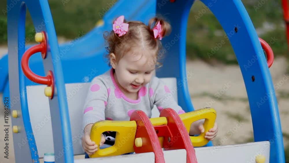 A little sweet girl is riding a carousel helicopter in an amusement park. A child plays in the playground. Entertainment for children A little sweet girl is riding a carousel helicopter in an amusement park. A child plays in the playground. Entertainment for children