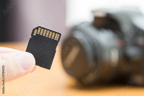 Hand men holding memory sd card for DSLR camera