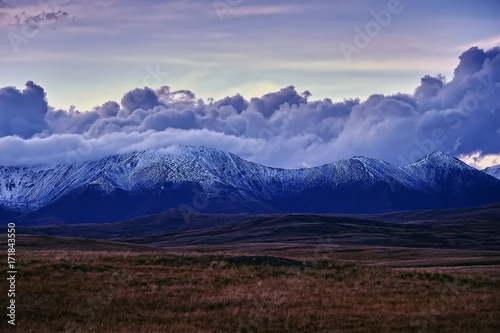 Beautiful autumn sunset landscape in the snow-capped mountains.