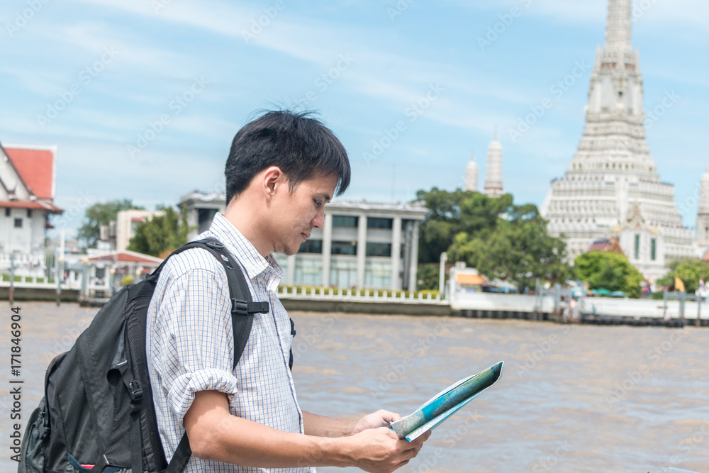 Asian tourists are watching the map before traveling around Thailand.