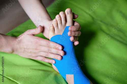 Quadro em tela Doctor taping woman injury leg.
