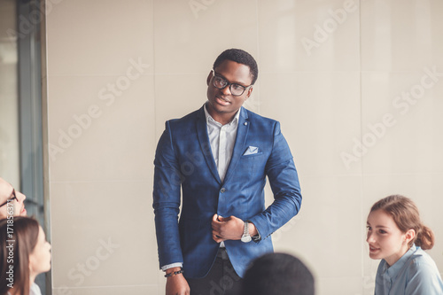 Portrait of a businessman in front of his team photo