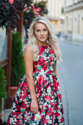 Portrait of a beautiful blonde in dress in flowers