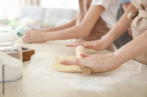 Family preparing dough together in kitchen. Cooking classes concept