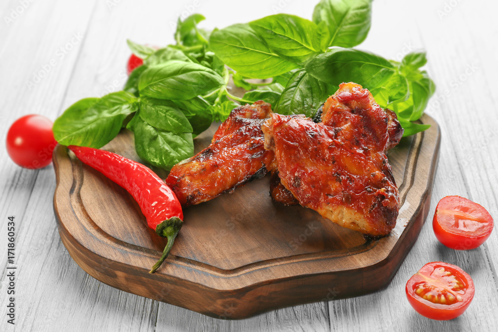 Tasty chicken wings in sauce on wooden board Tasty chicken wings in sauce on wooden board