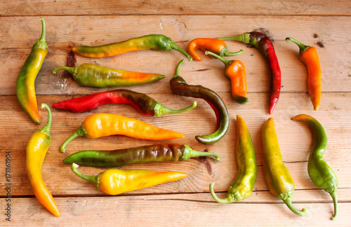 peperoncini piccanti di colore giallo,verde e rosso su un tavolo di legno photo