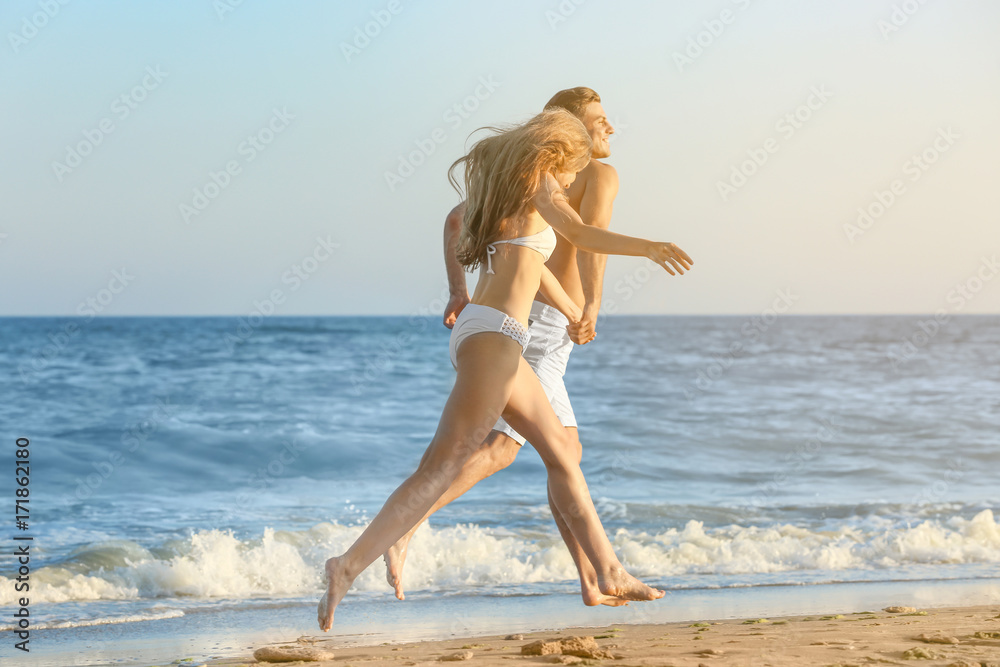 Fototapeta premium Happy young couple on sea beach