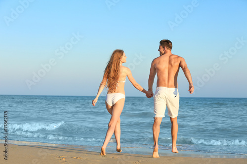 Happy young couple on sea b...