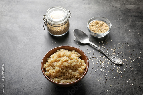 Bowl with boiled white quinoa grains on kitchen table