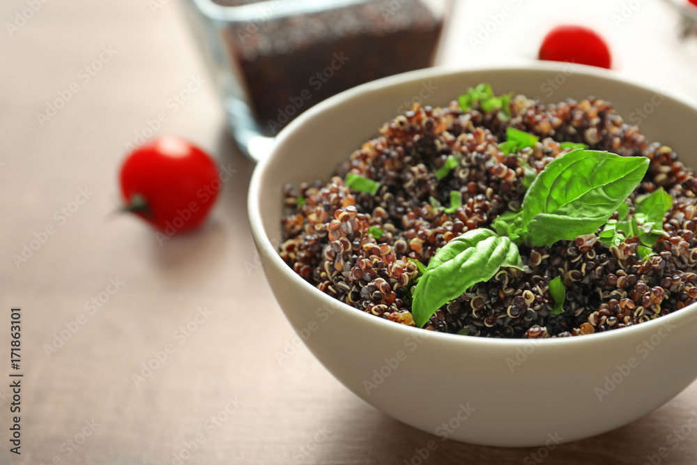 Bowl with boiled quinoa grains on wooden table Bowl with boiled quinoa grains on wooden table