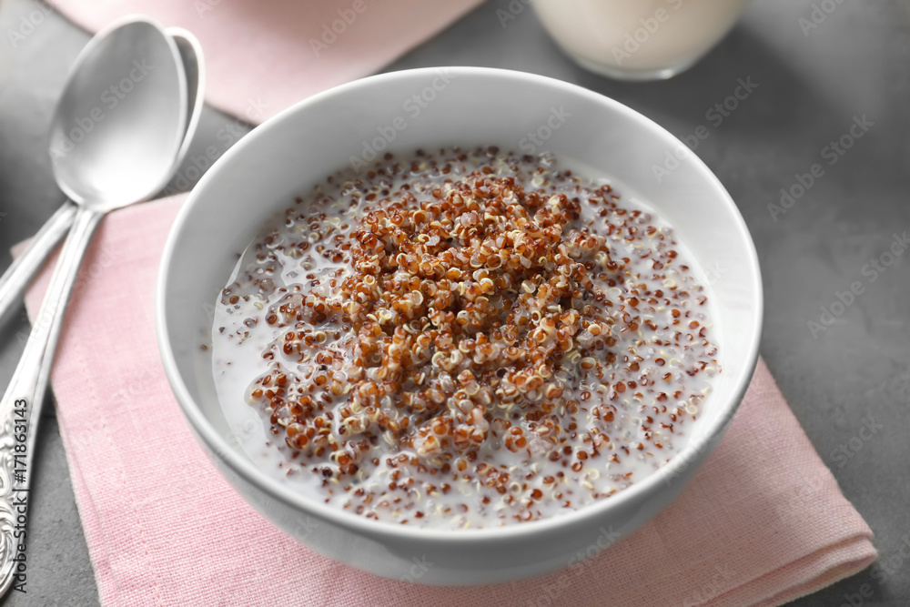 Bowl with boiled quinoa grains and milk on kitchen table