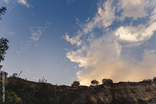 Partly cloudy. Beautiful sky. Landscape with the sky. Patterns from the clouds. Summer. Trees on a cliff. Beauty of the sky.